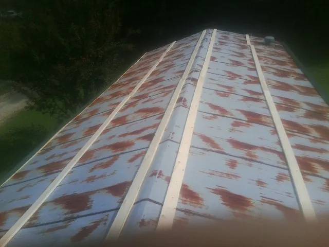 Rusted metal roof panels with new wood purlins before replacement — Storm Damage Roof Repair in Salina by Roofing Brothers